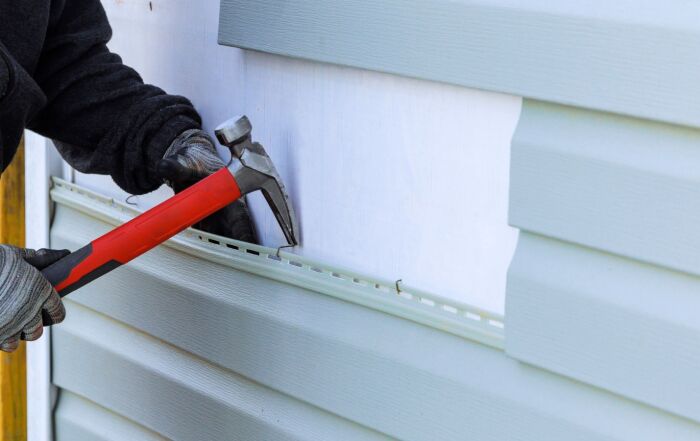 Contractor removes old vinyl siding in Richmond, VA.