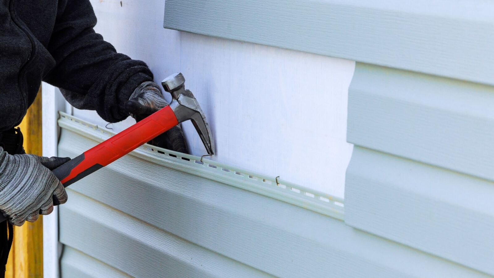 Contractor removes old vinyl siding in Richmond, VA.